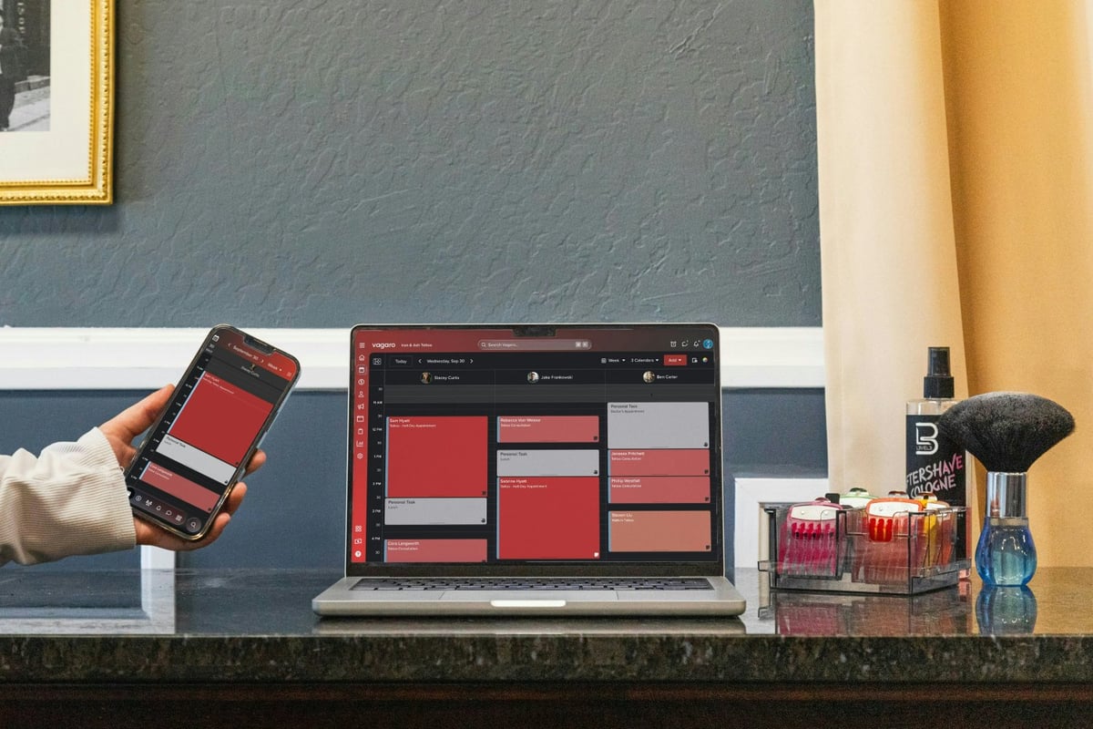 Business owner reviewing online booking and payment dashboard on laptop and phone