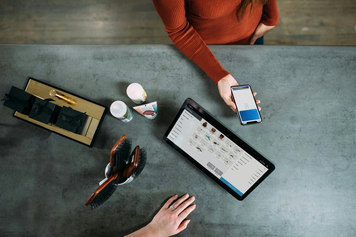 Customer paying at a small business counter by scanning a QR code with a smartphone