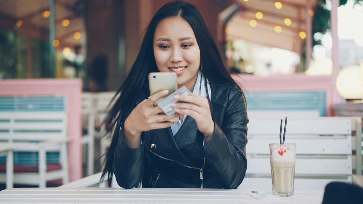 Customer using a smartphone at a café to pay online